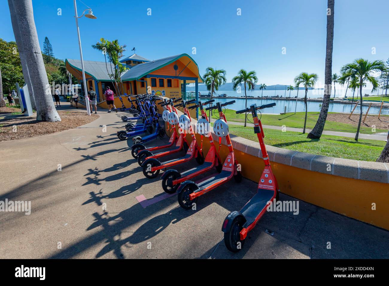 Row of red electric scooters for hire, Strand Park, Townsville, Far North Queensland, FNQ, QLD, Australia Stock Photo