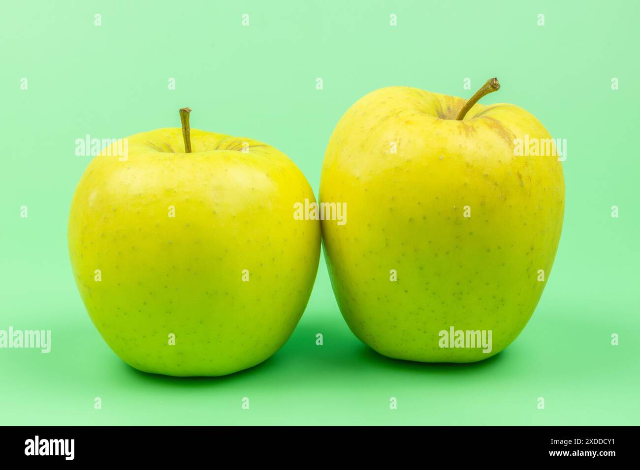 two apples, close-up, isolated on a green background Stock Photo