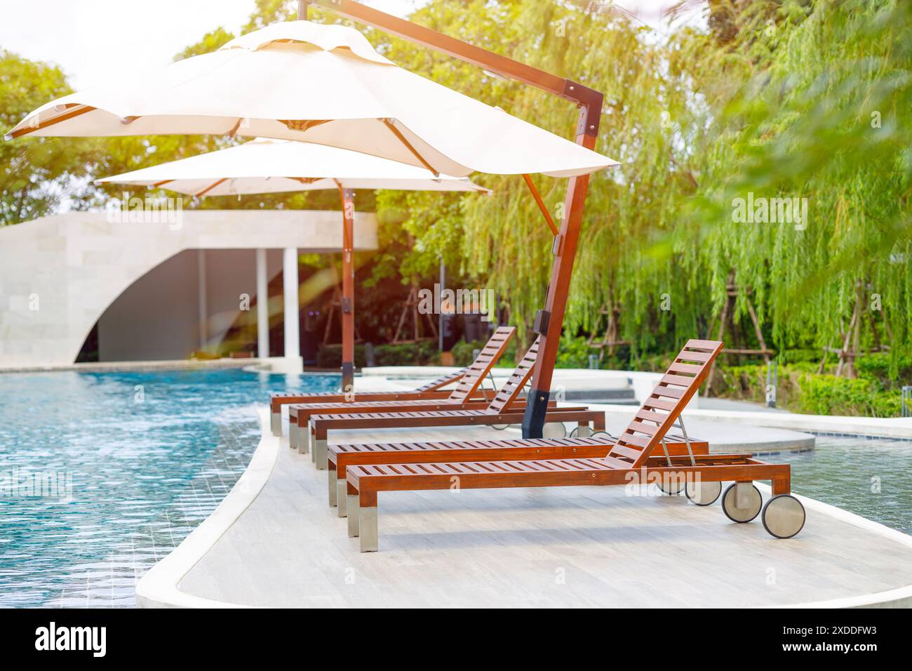 Outdoor lounge sunbeds near swimming pool, pool bed sunbath at resort