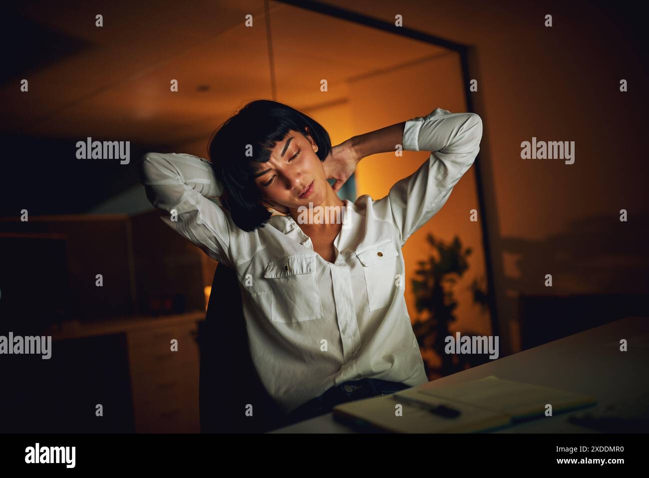 Asian woman, neck pain and stress in night at office with emergency, tired or muscle fatigue at startup. Person, accident or burnout with massage Stock Photo