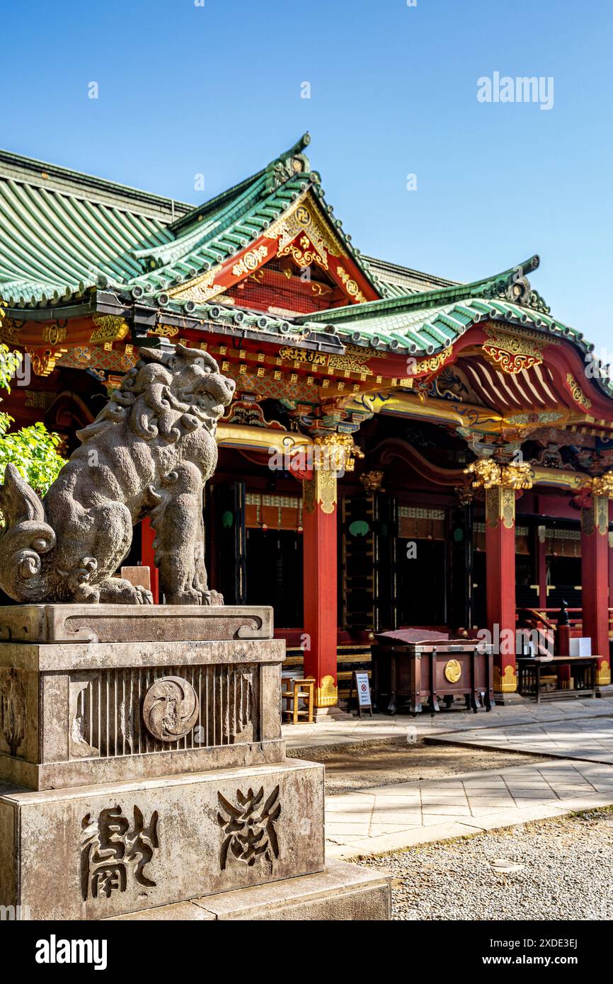 Main hall called 'honden' and statue of a komainu, in Nezu Jinja, a Shinto shrine established in Tokugawa era and located in the Bunkyō ward of Tokyo Stock Photo