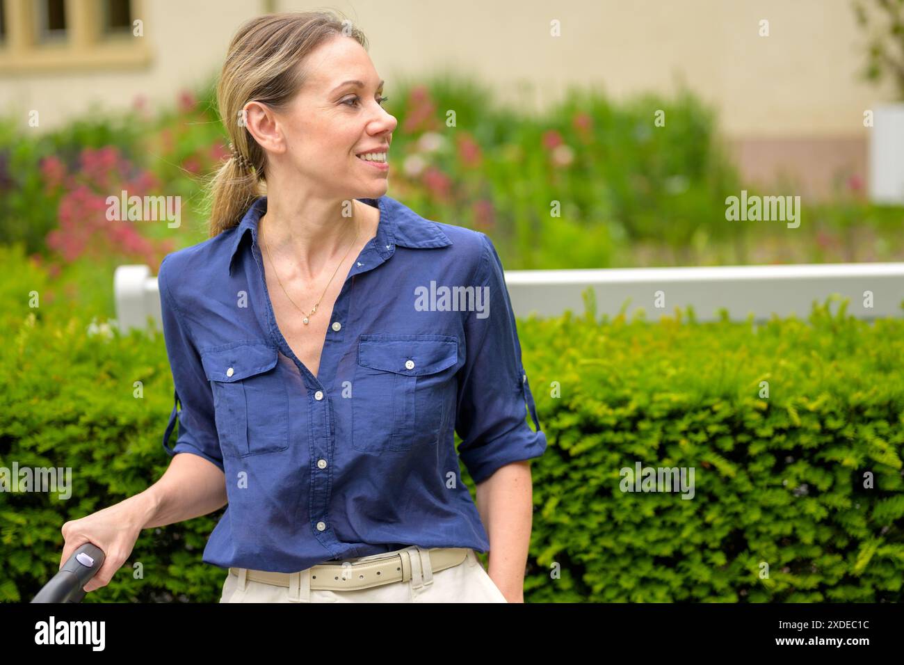 A woman wearing a blue shirt and beige pants is enjoying her time ...