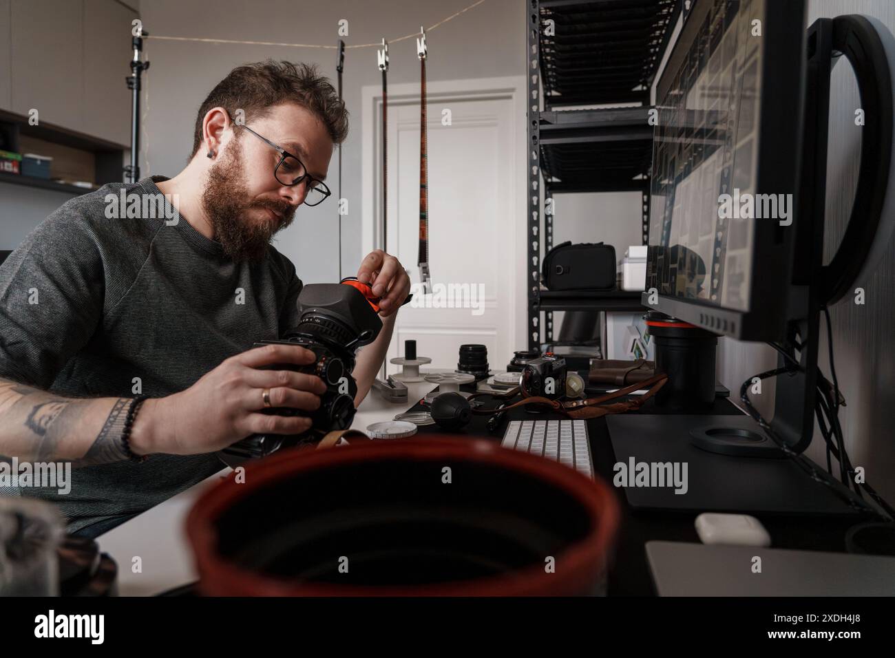 Photographer cleaning camera lens in a well-equipped studio Stock Photo ...