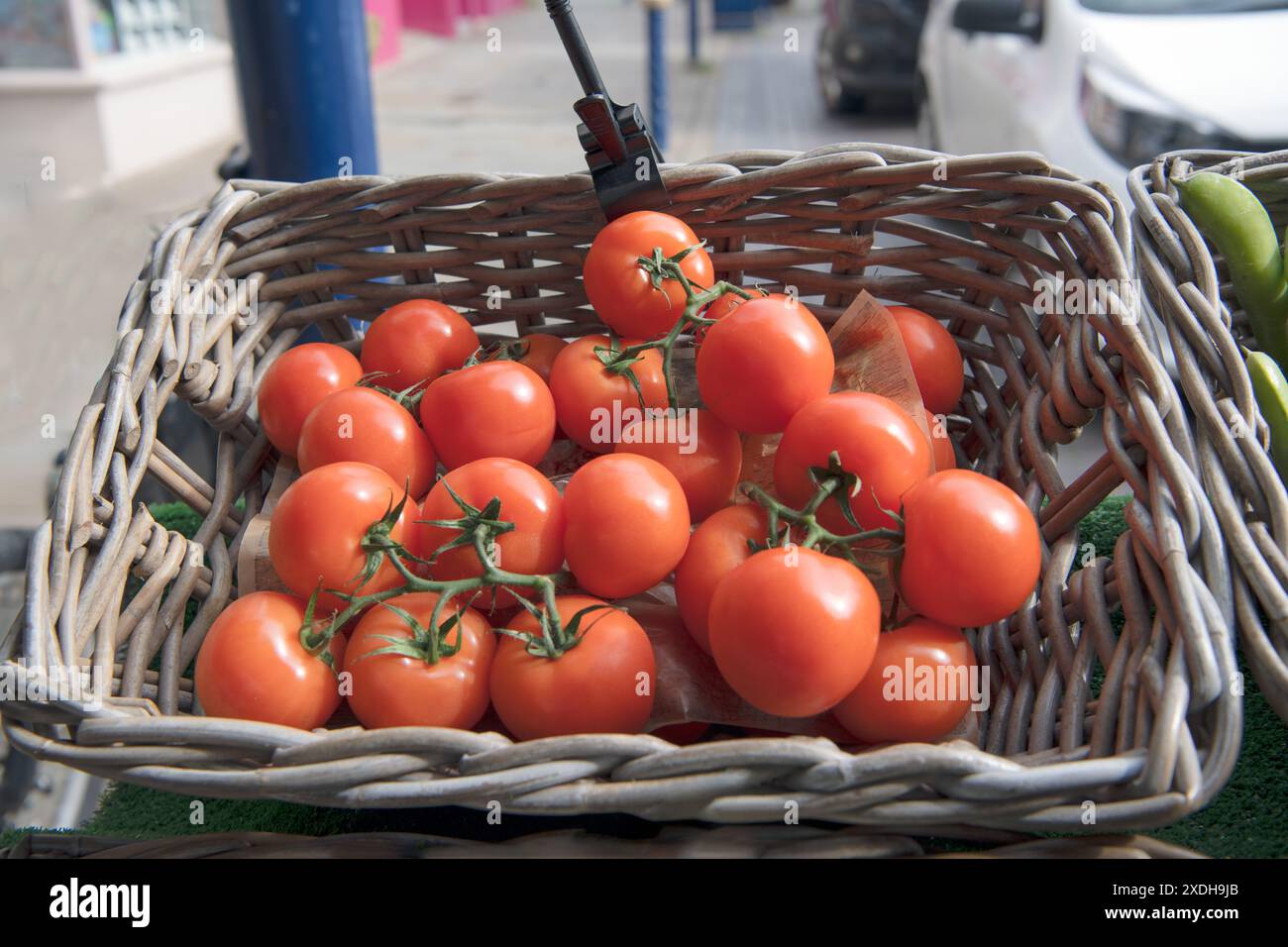 Red tomatoes in a wicker basket with blurred street background Stock ...