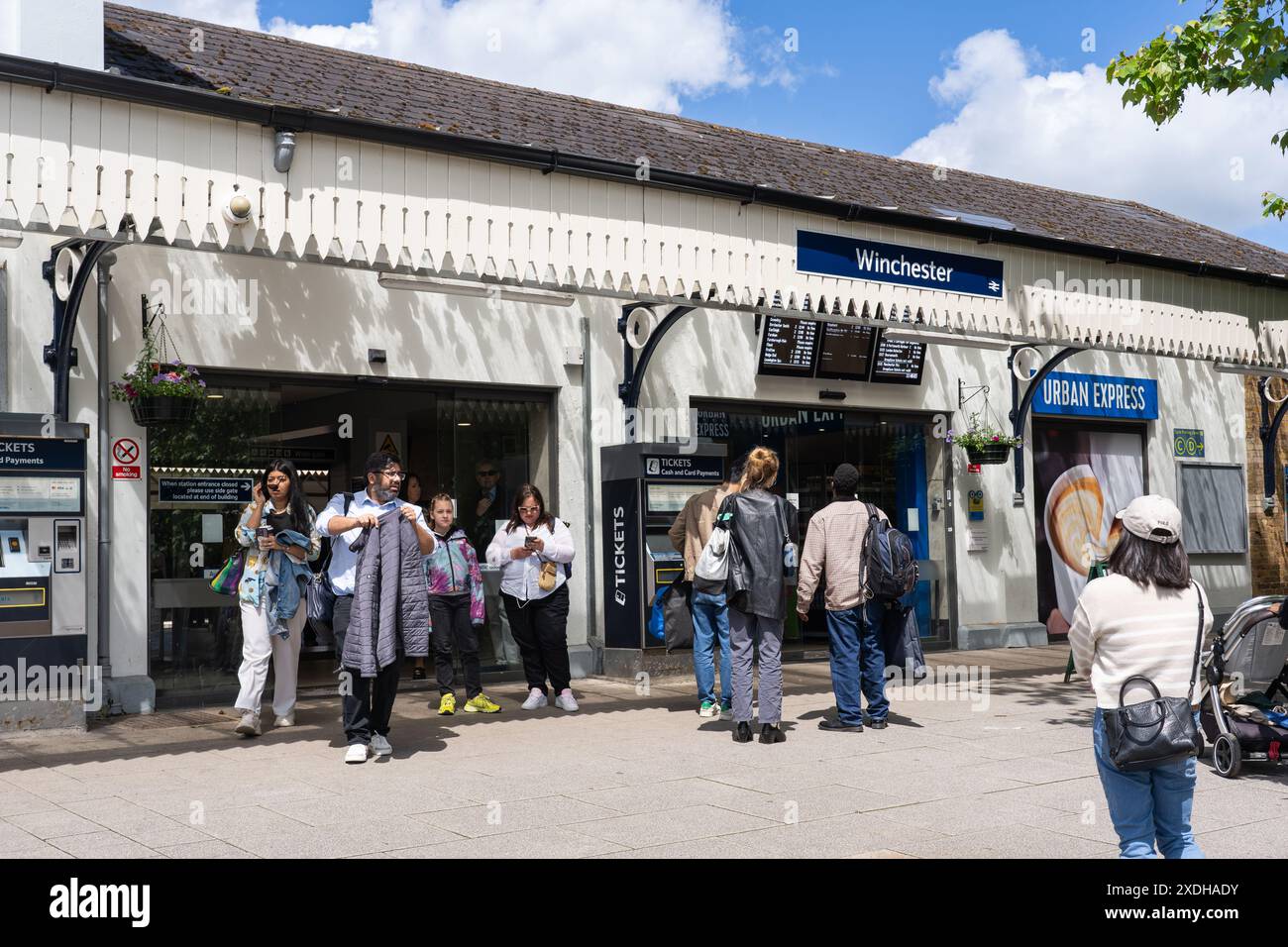 Visitors and commuters at Winchester train station - every inch the traditional Victorian railway building, with a crisp white facade. England Stock Photo