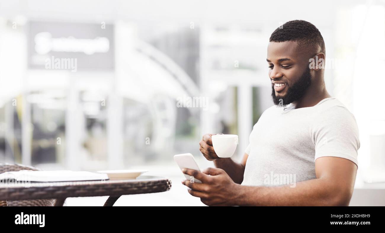 Man Using Smartphone and Coffee at Cafe Stock Photo