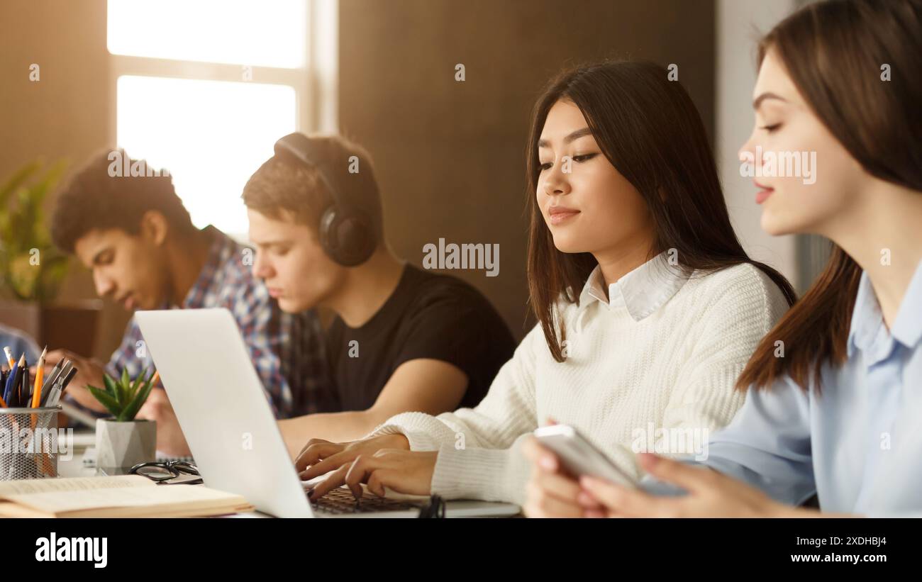 Multiracial students engaged in library study session Stock Photo