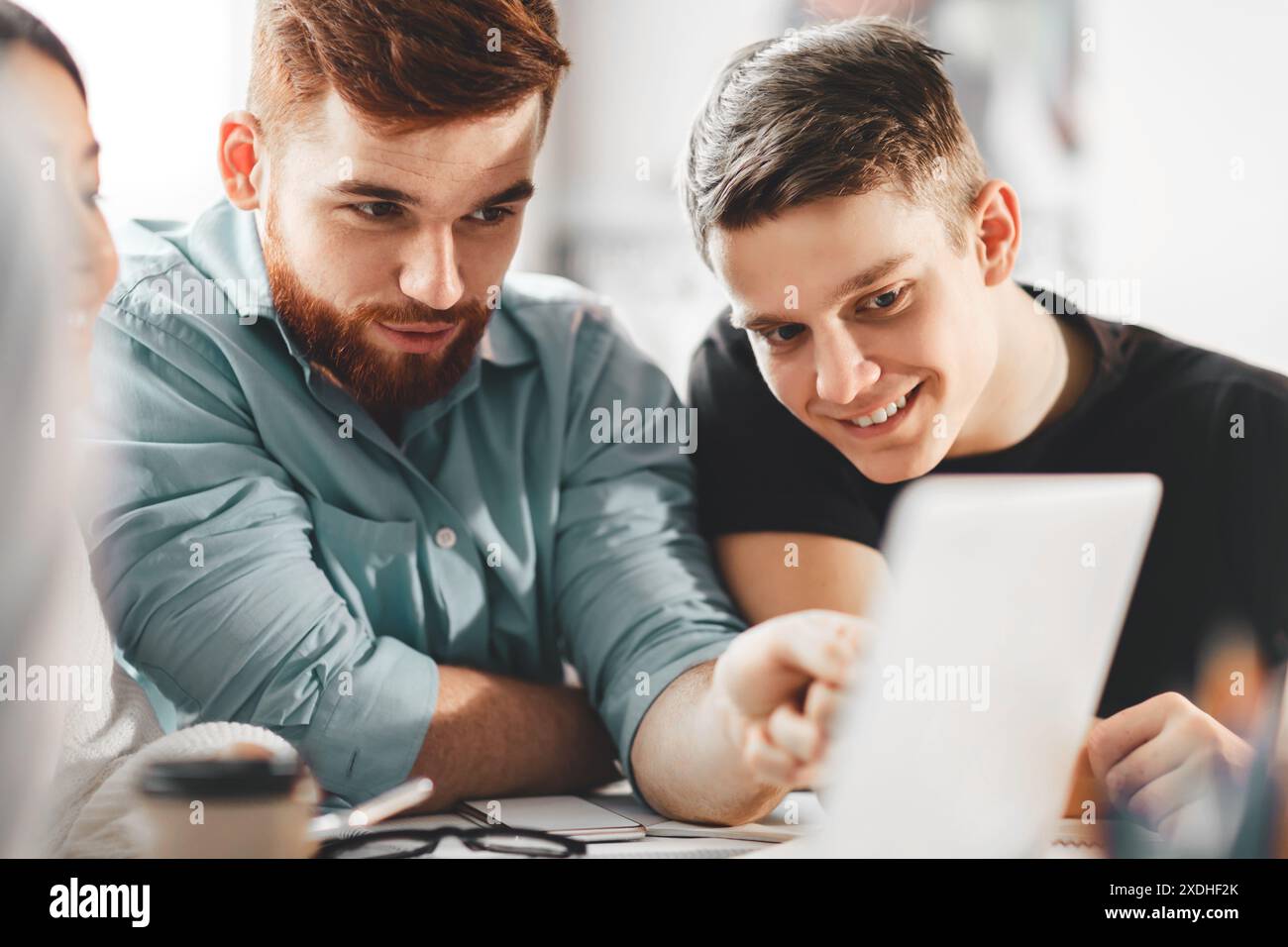 Two Colleagues Collaborating on Project Using Tablet in Office Setting Stock Photo