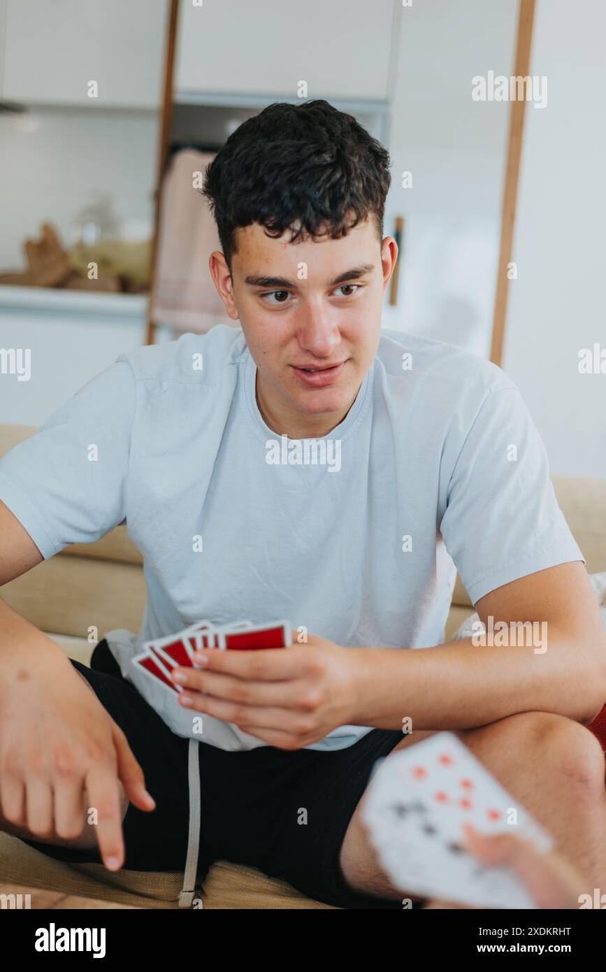 Young man enjoying a card game at home with family and friends Stock ...