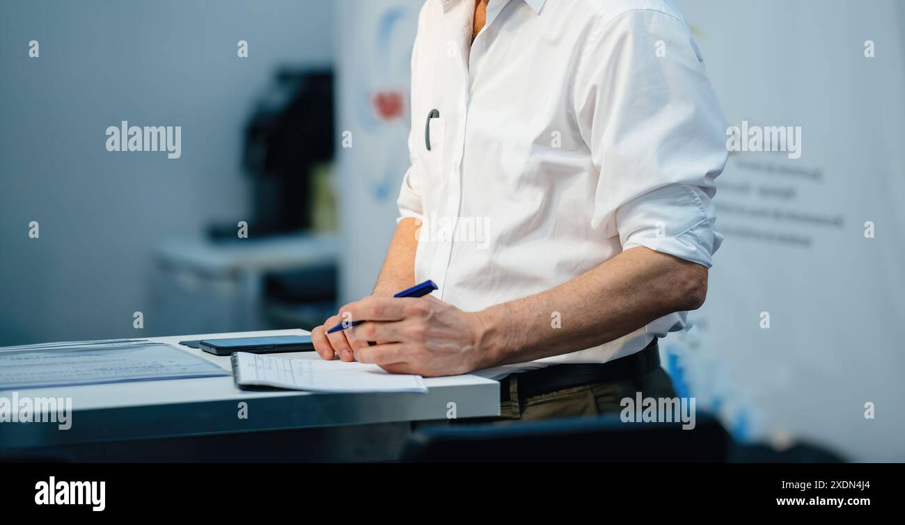 Teacher speaking to students in a large room during a course, engaging the class with a dynamic lecture, fostering an interactive and educational envi Stock Photo
