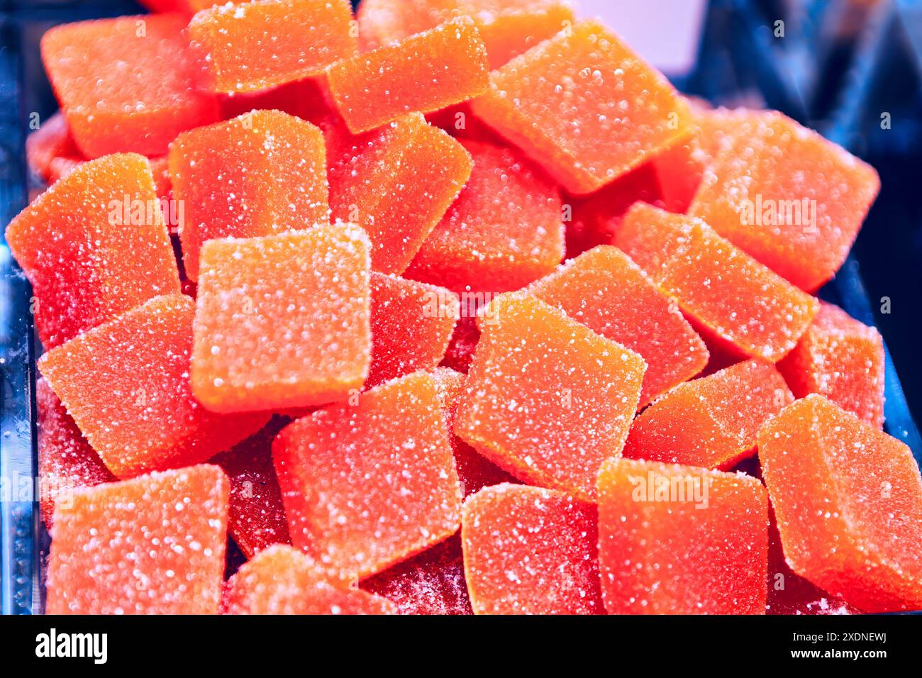 Pile of orange candy with a lot of sugar on it. The candy is in the