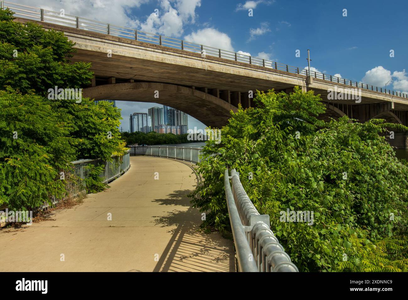 A curved pedestrian pathway on Lady Bird Lake under the South Congress ...