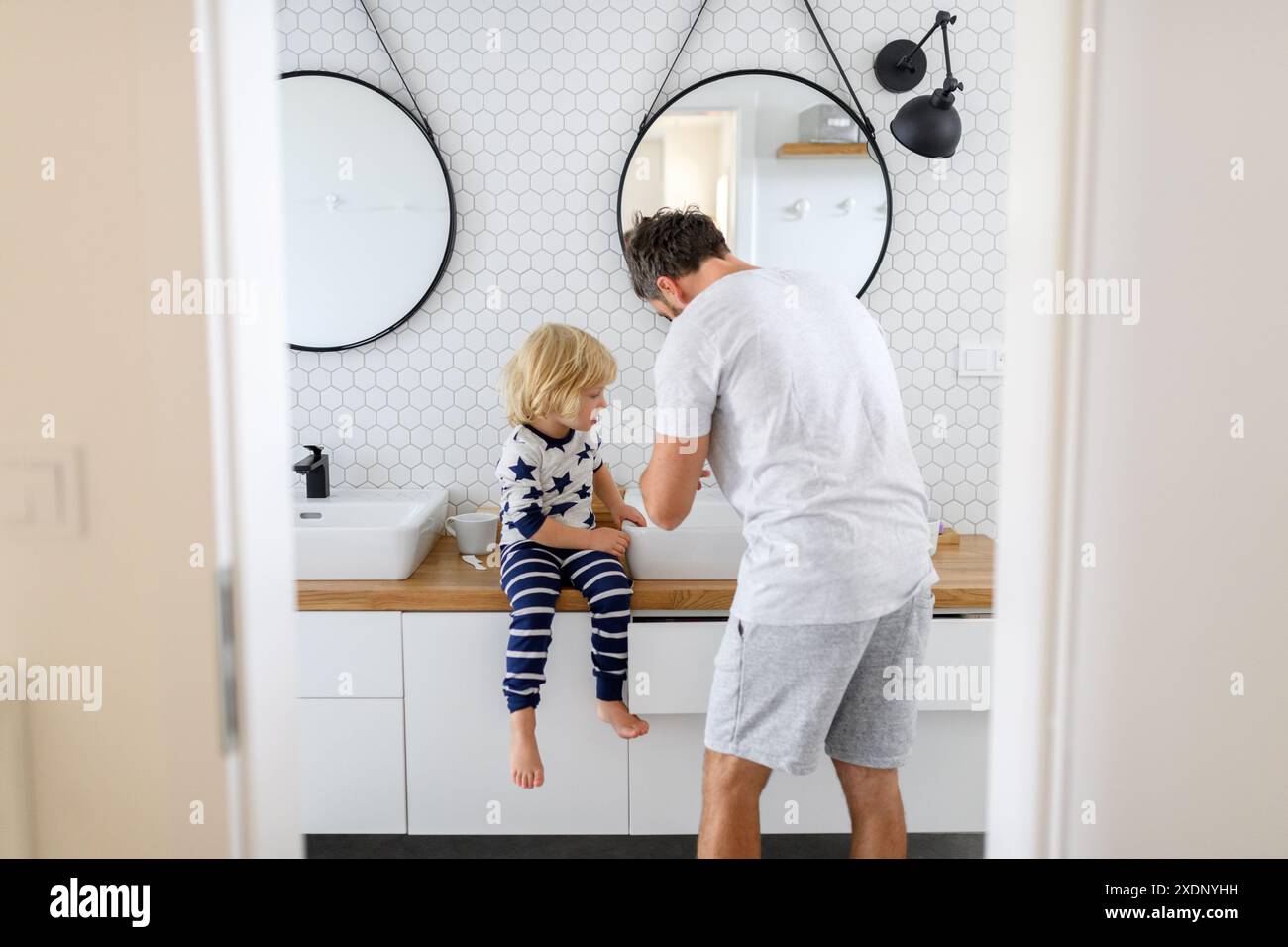 Father brushing son's teeth. Morning routine for young boy before going ...