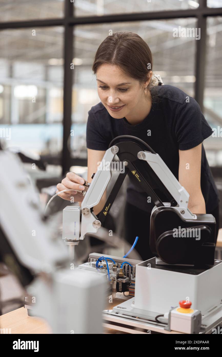 Engineer women learning education in Industrial Robotics program with robot arm simulation model in university engineering lab classroom. Stock Photo