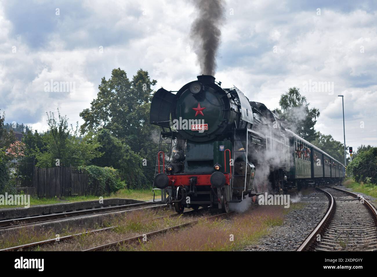 Historic Steam Train Journey: Waving Passengers and Billowing Smoke Stock Photo