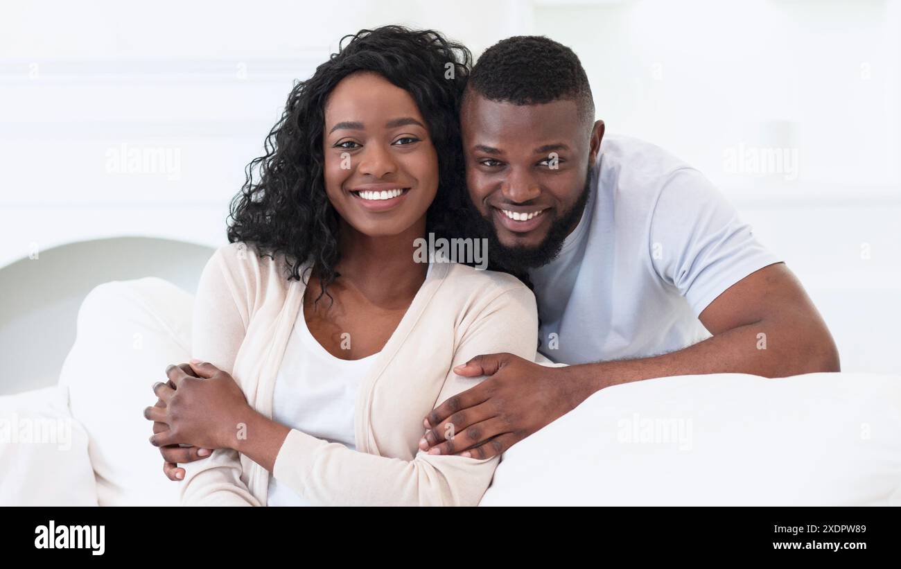 Happy Couple Posing Together on a Bed Stock Photo