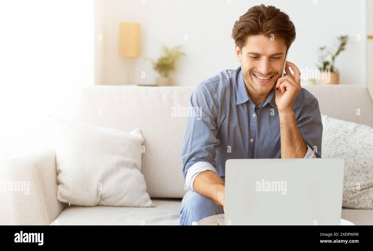 Man Smiling While on Phone Call and Using Laptop Stock Photo