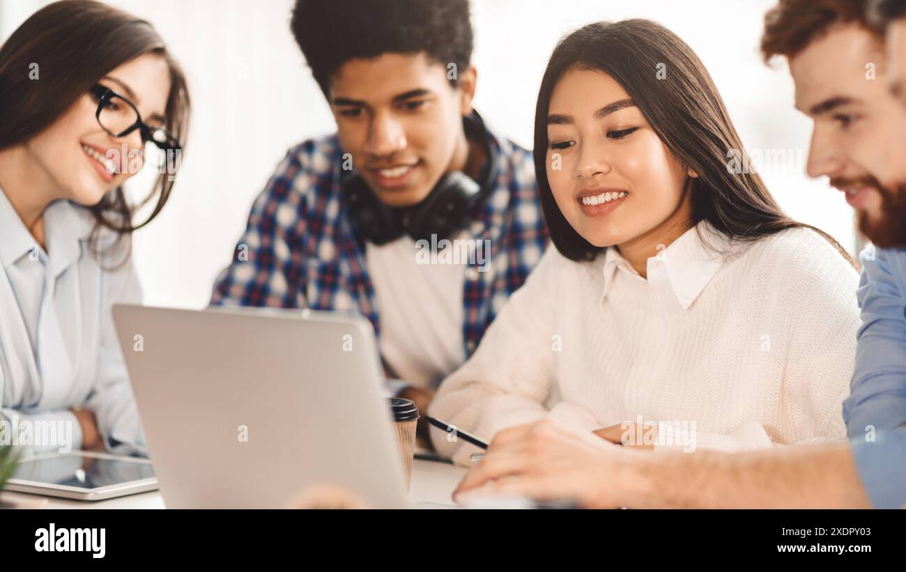 Diverse students focused on digital learning indoors Stock Photo