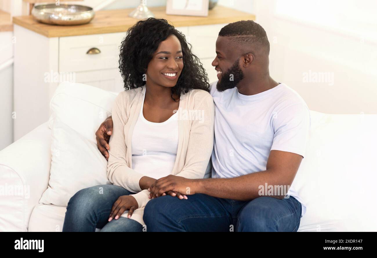 Happy romantic couple sitting hi-res stock photography and images - Alamy