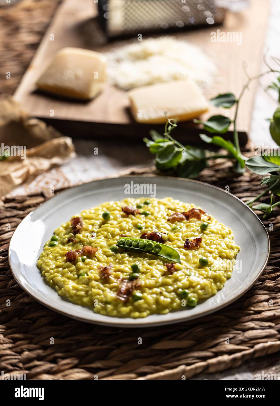 Italian saffron risotto with peas and bacon creatively served on a plate. Stock Photo