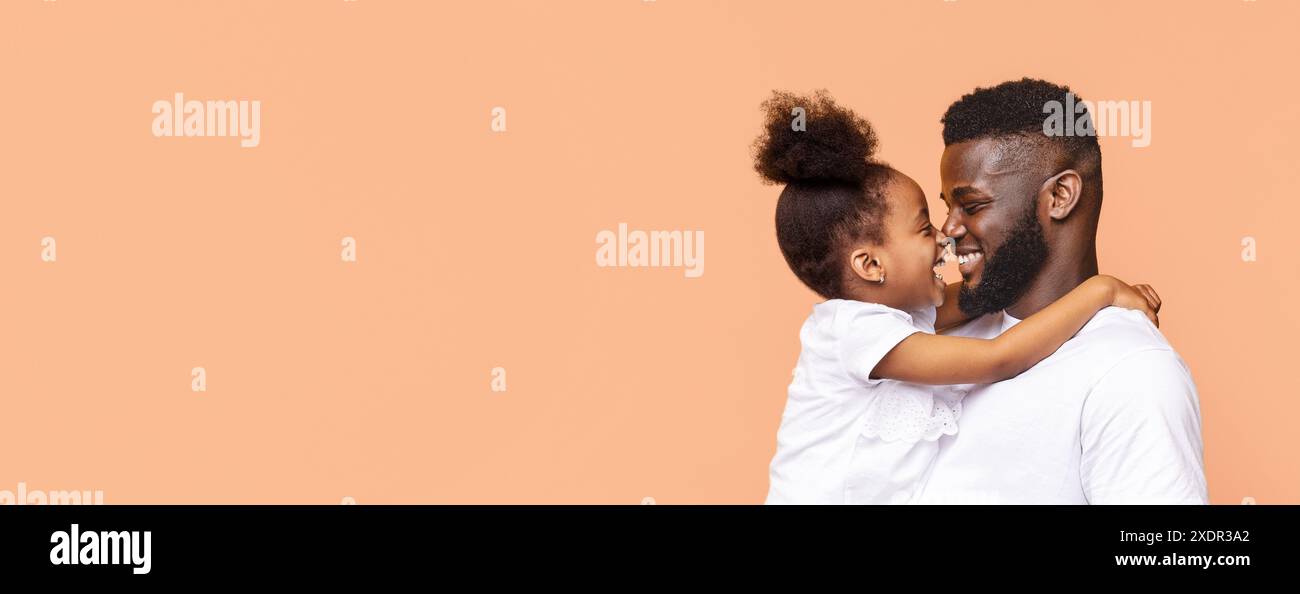 Happy Black Father And Daughter Hugging Against Peach Background Stock ...