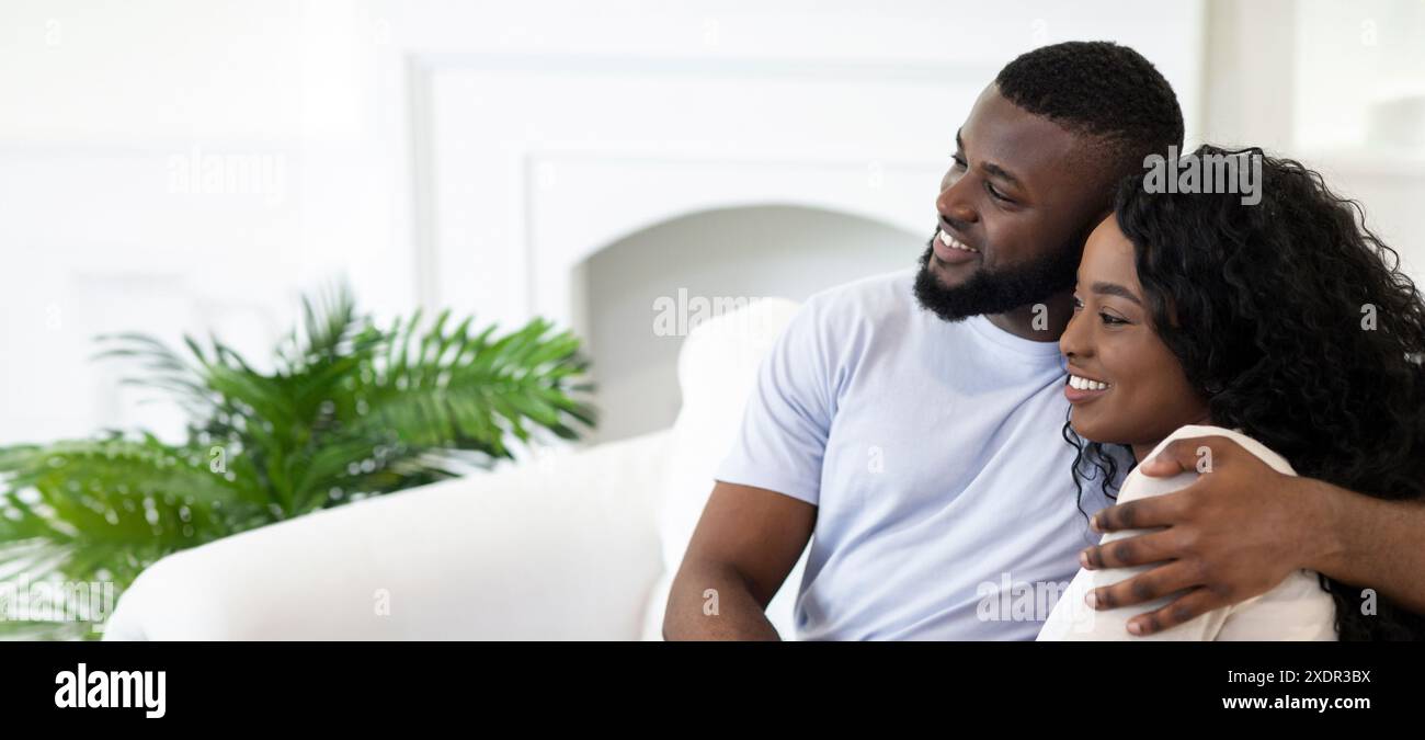 Couple Relaxing On White Couch In Home Stock Photo