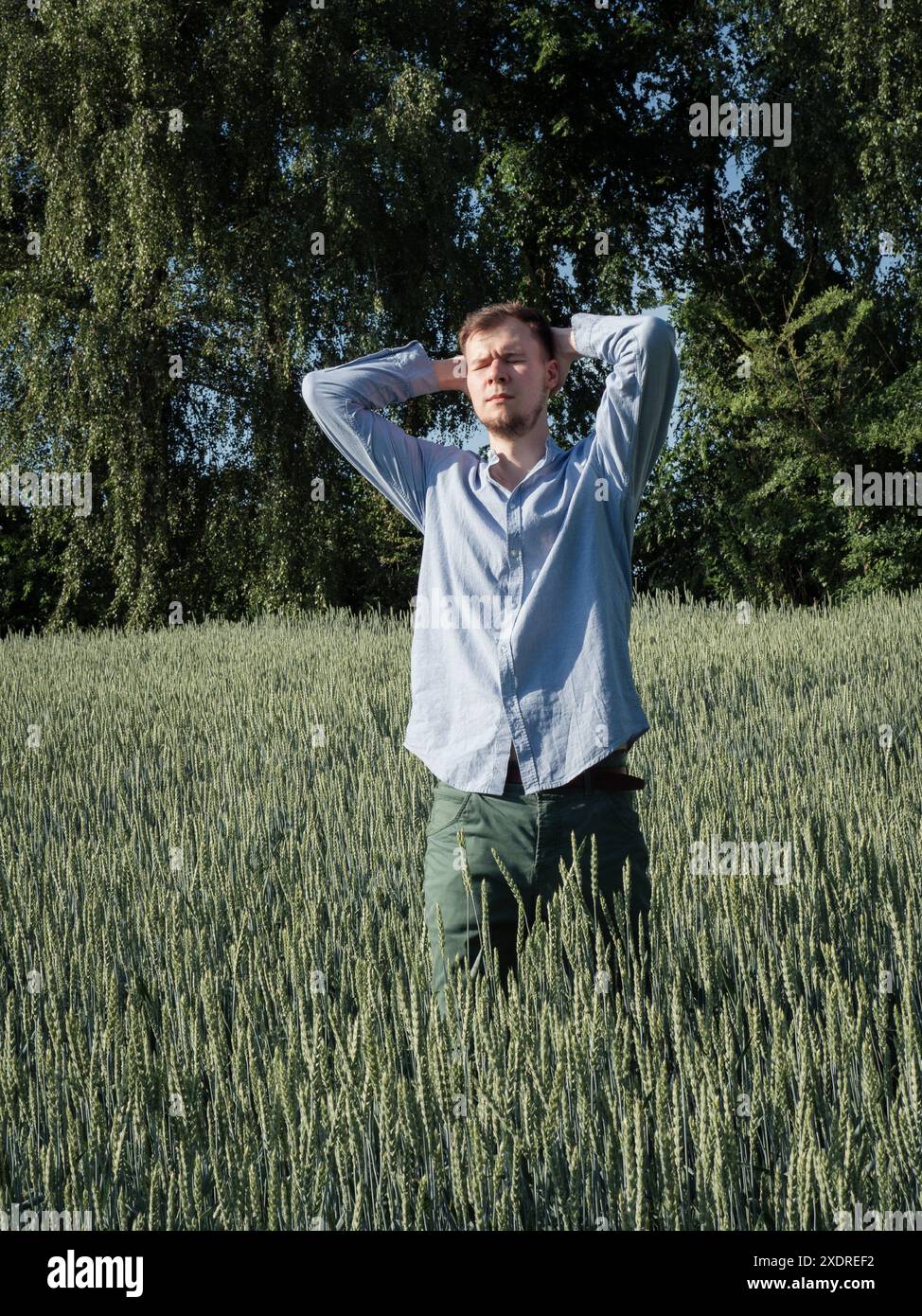 Portrait of a young man in the green Ukrainian field standing with his ...