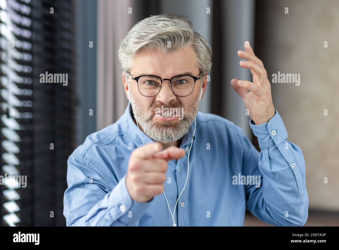 mature-man-displaying-anger-and-frustration-during-virtual-meeting-in
