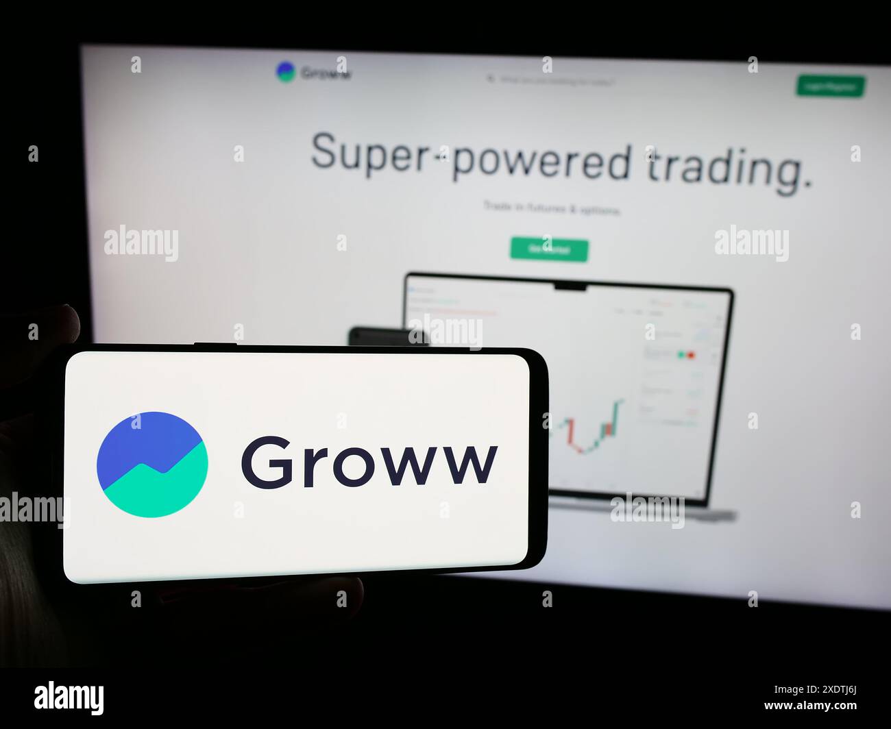 Person holding smartphone with logo of Indian fintech company Groww Invest Tech Pvt. Ltd. in front of website. Focus on phone display. Stock Photo