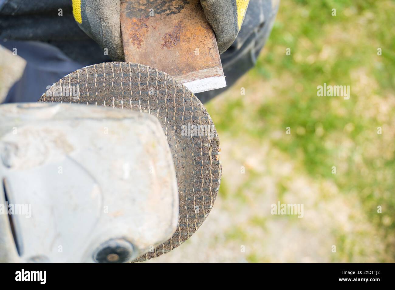 Man holding in hands axe closeup and using sharpening machine. Senior ...
