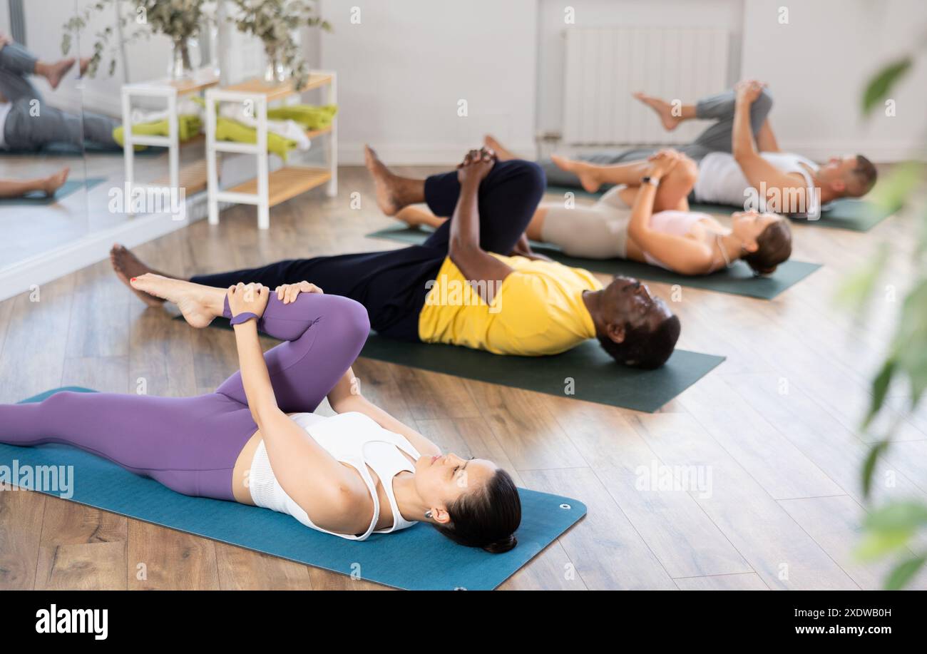 Young woman performing Eka Pada Apanasana in yoga class Stock Photo - Alamy