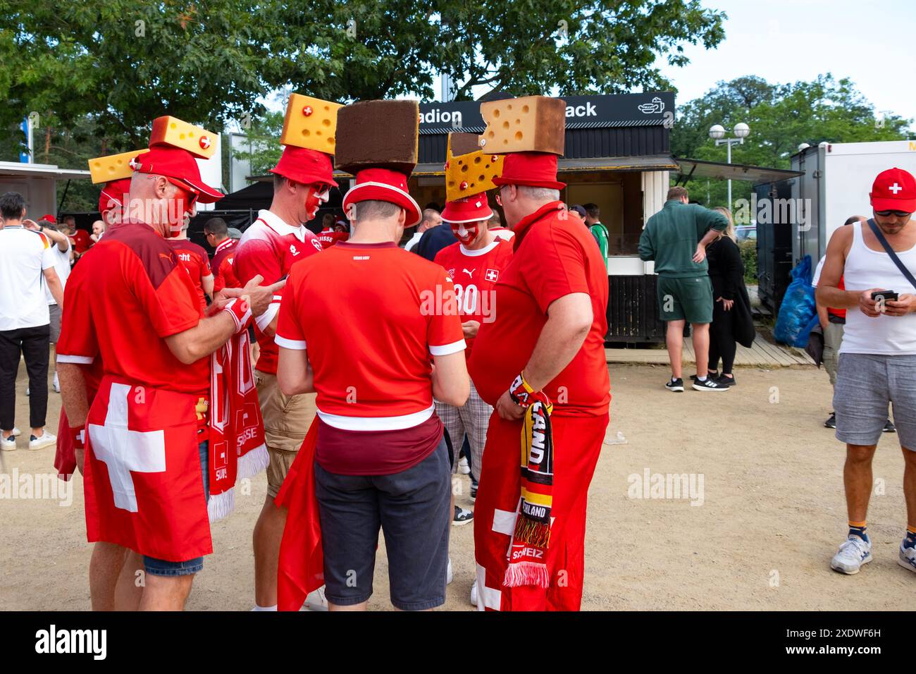 Swiss fans in red outfits, proudly displaying national symbols and flags, await UEFA EURO 2024 match, Frankfurt, Germany – June 23, 2024 Stock Photo