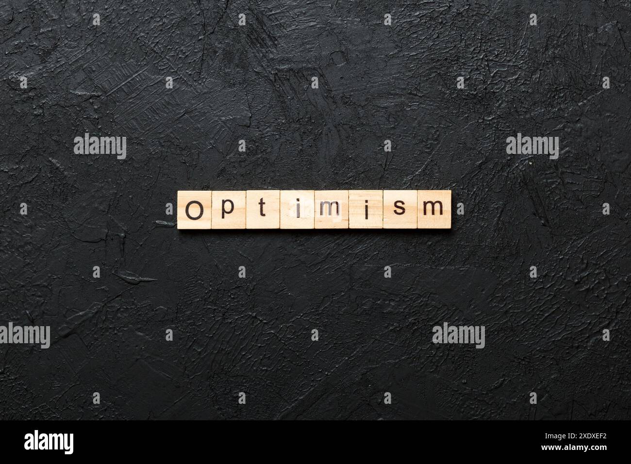 Optimism word written on wood block. Optimism text on cement table for ...