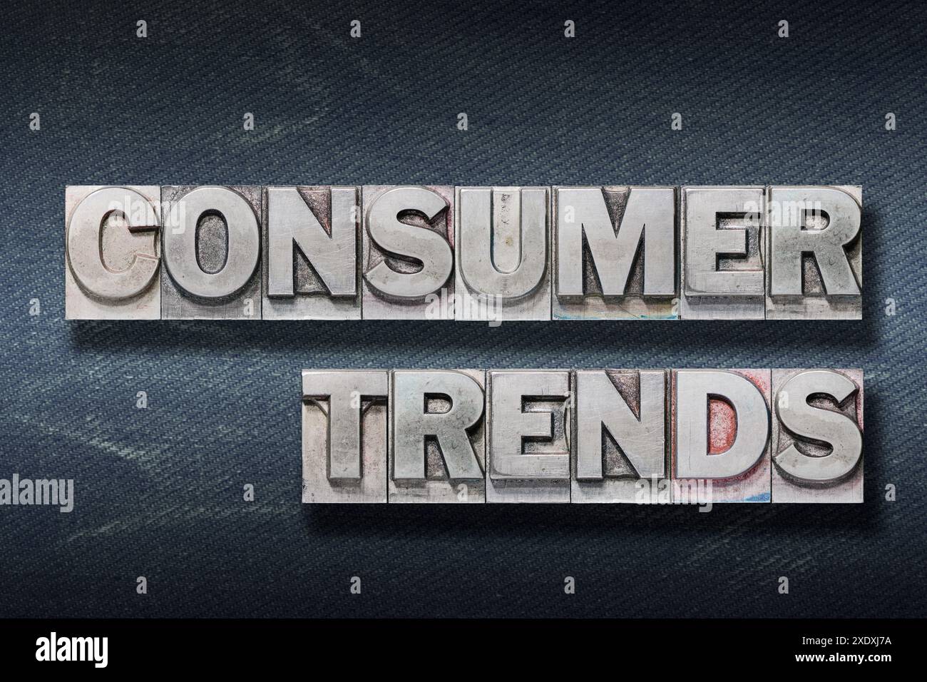 consumer trends phrase made from metallic letterpress on dark jeans background Stock Photo