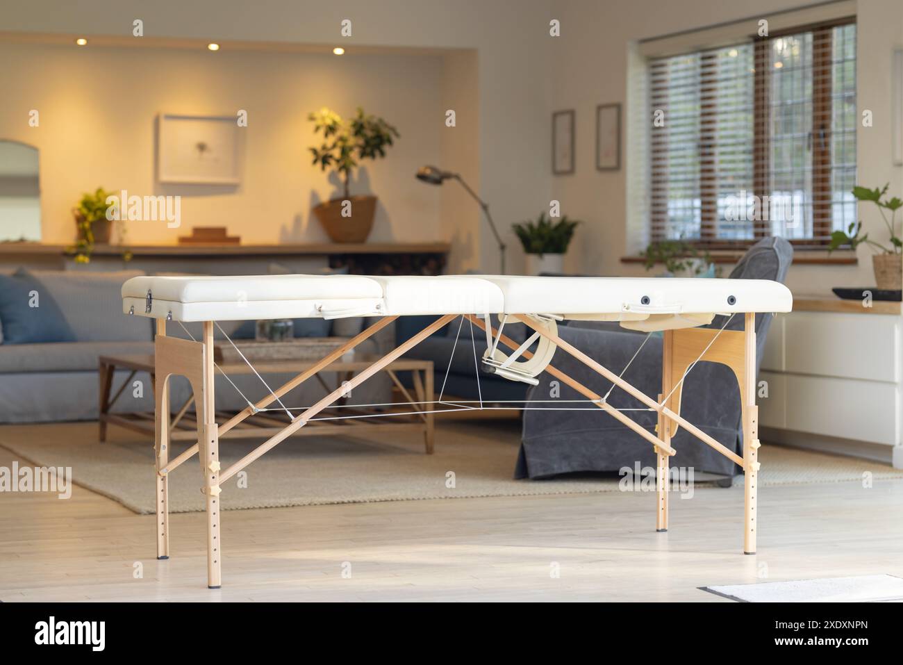 Massage table in modern living room, ready for physiotherapy session at home, copy space Stock Photo