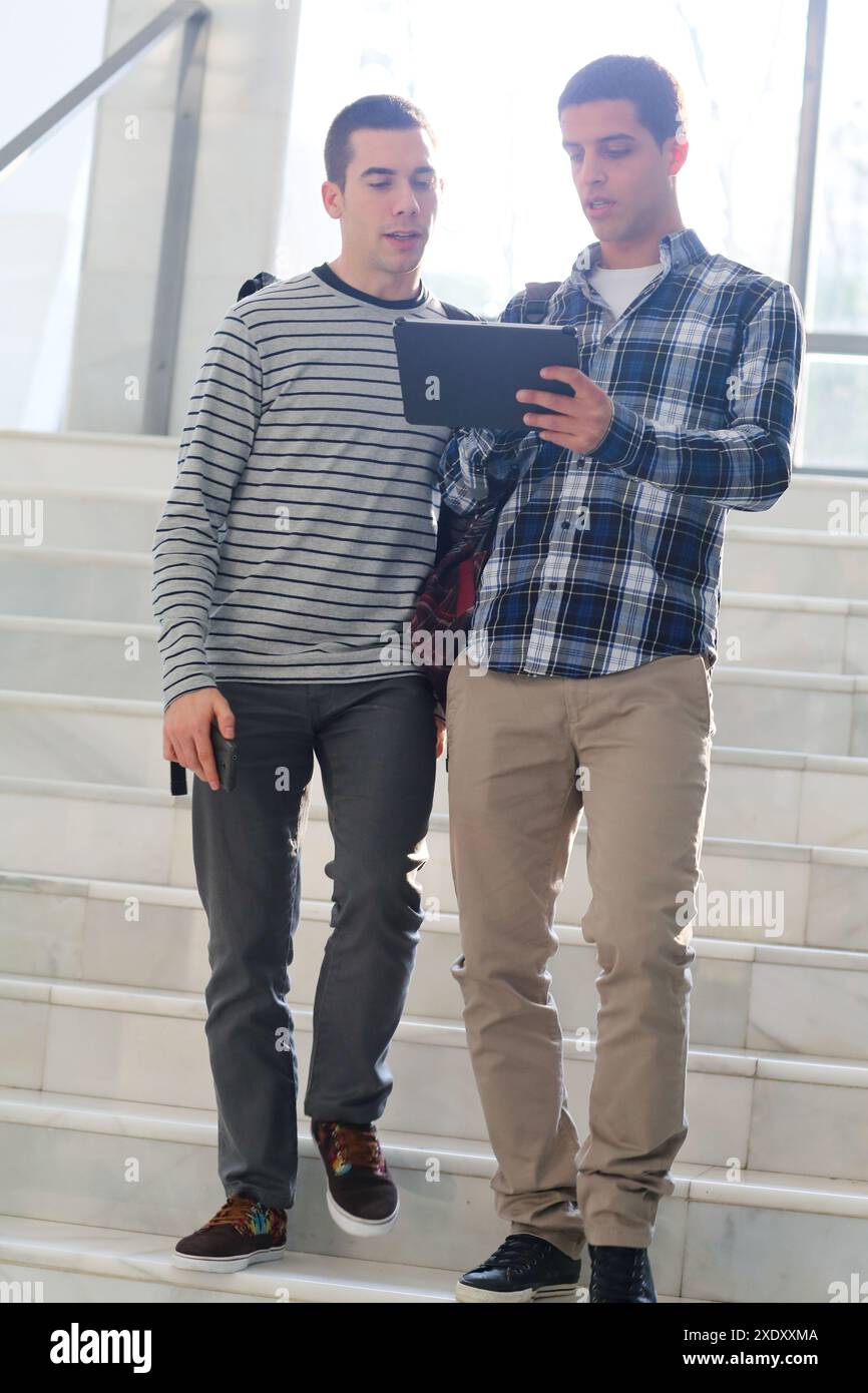 Young students at campus using digital tablet Stock Photo