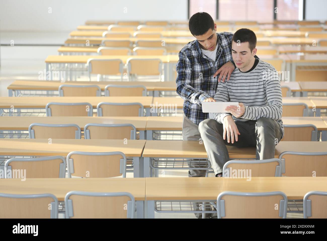 Young students at campus using digital tablet Stock Photo