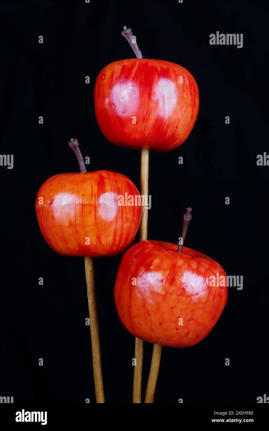 Red  handmade   artificial plastic apples for fir tree decoration  isolated on black macro Stock Photo