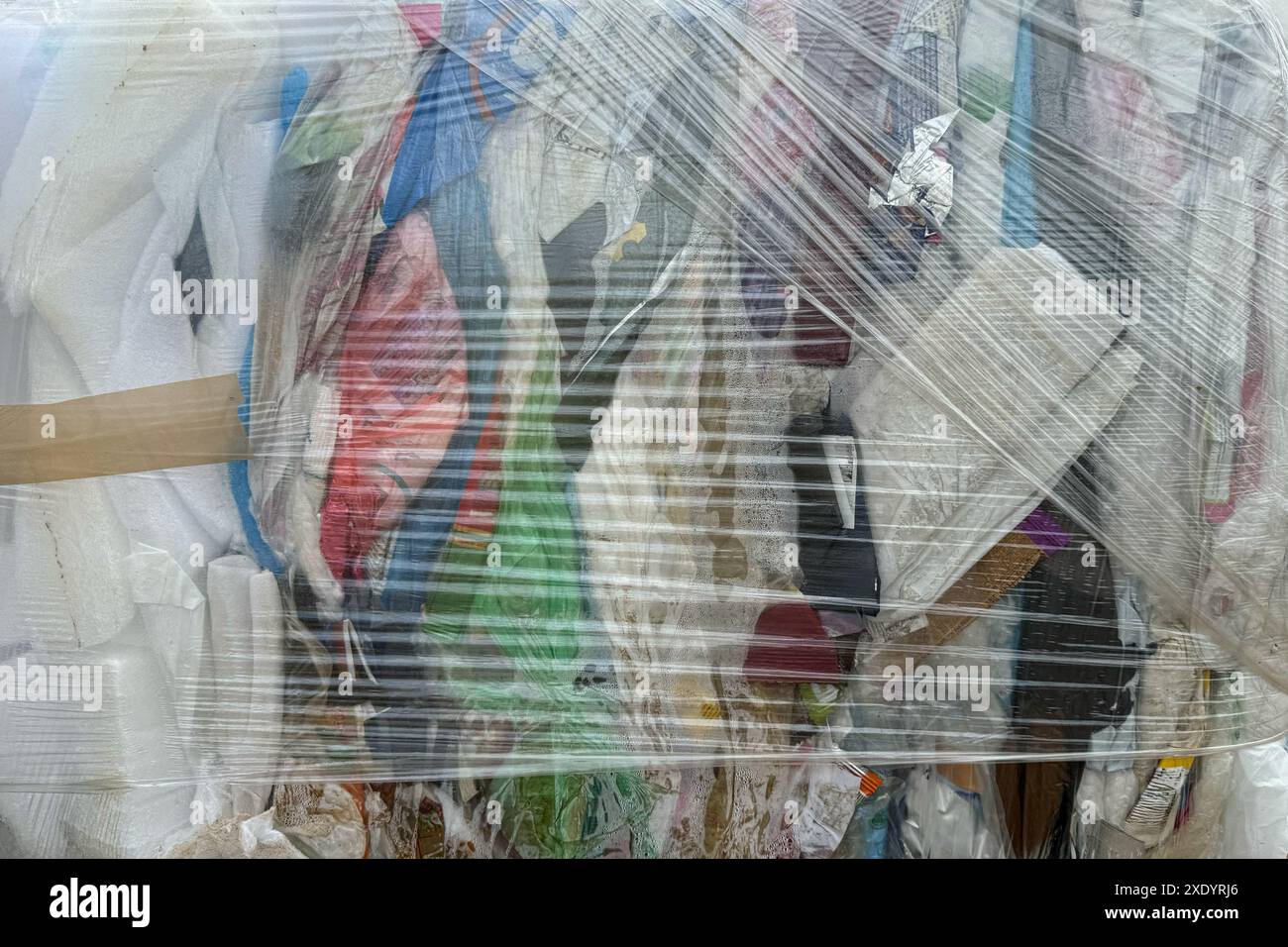 A tightly compressed bale of mixed plastic and foam waste materials ...