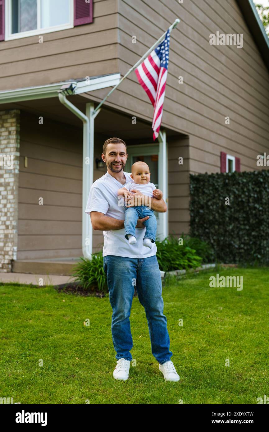 Dad embracing young son in front of their house. Fatherhood and Father ...