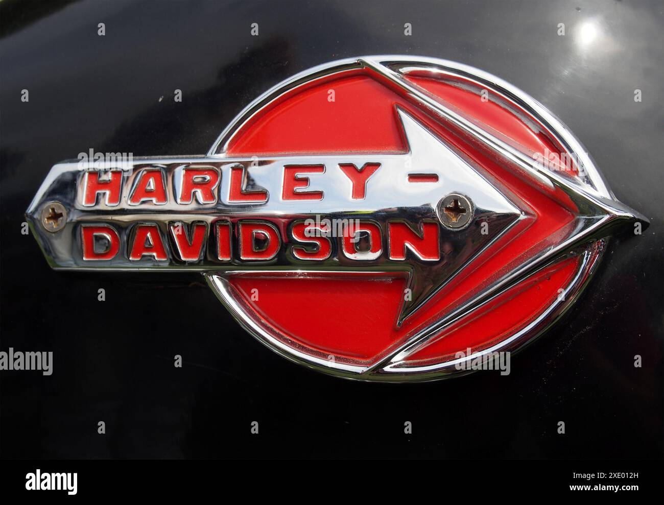 Close up of a and chrome harley davidson logo on the tank of a black motorcycle Stock Photo