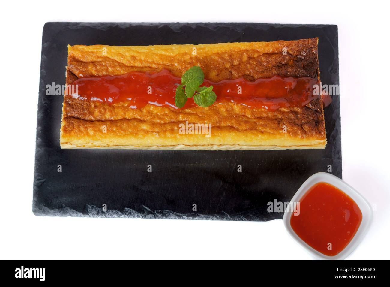 Cheesecake with strawberry jam on black board Stock Photo