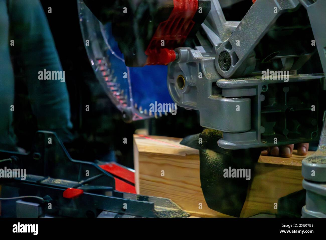 A worker cuts a wooden block using a circular saw Stock Photo