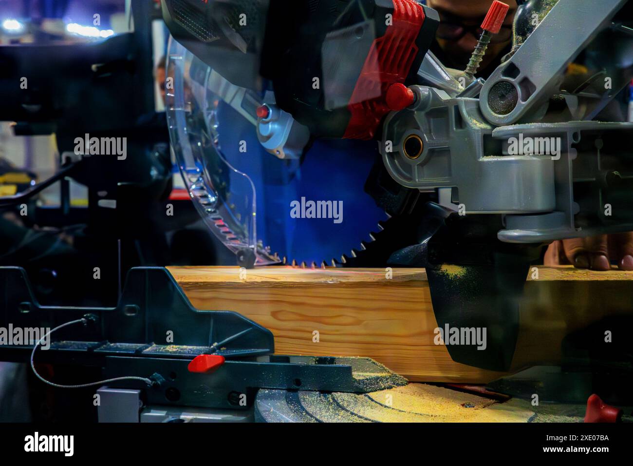 A worker cuts a wooden block using a circular saw Stock Photo