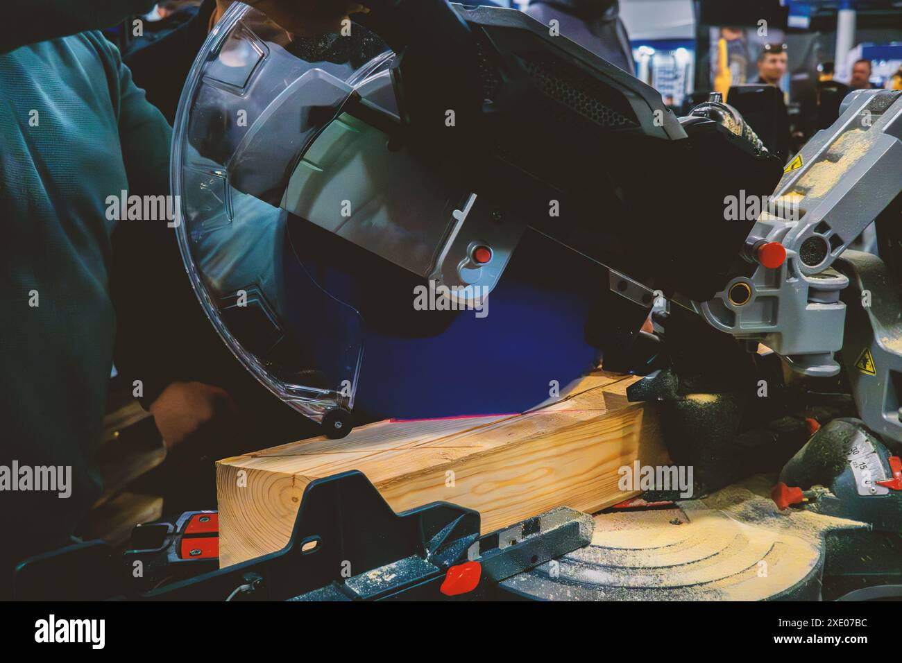 A worker cuts a wooden block using a circular saw Stock Photo