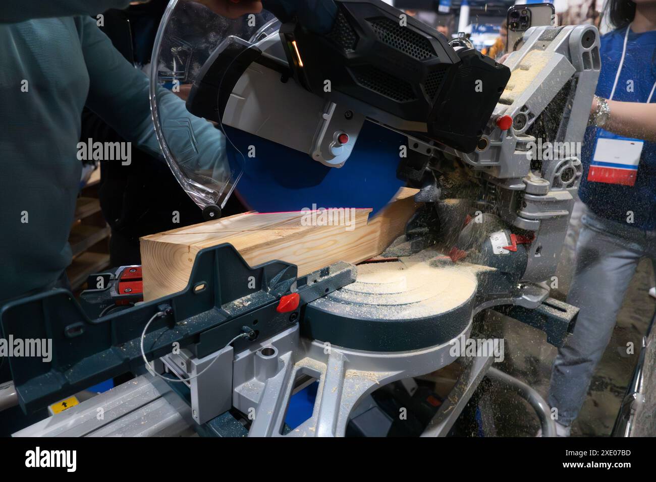 A worker cuts a wooden block using a circular saw Stock Photo