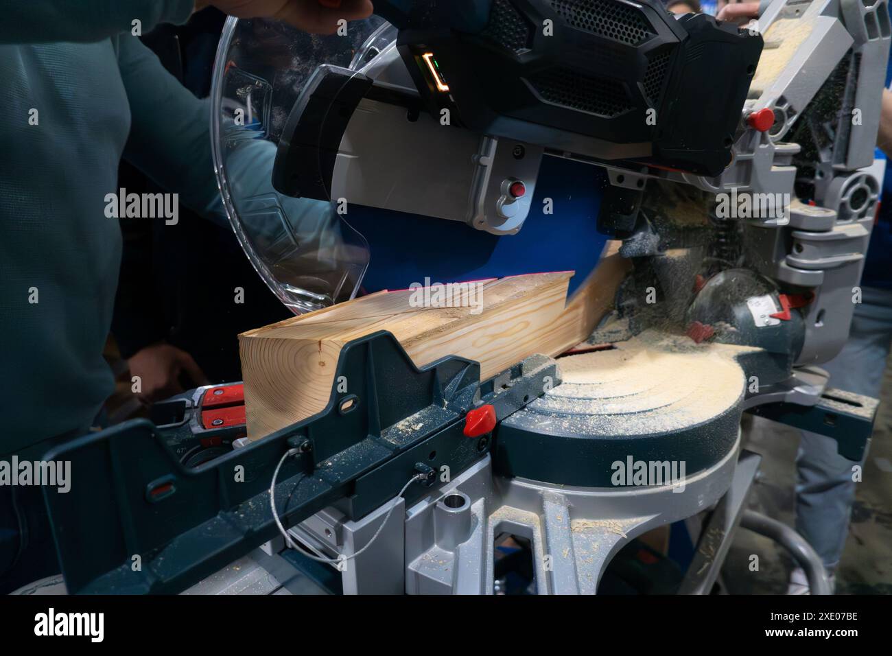 A worker cuts a wooden block using a circular saw Stock Photo