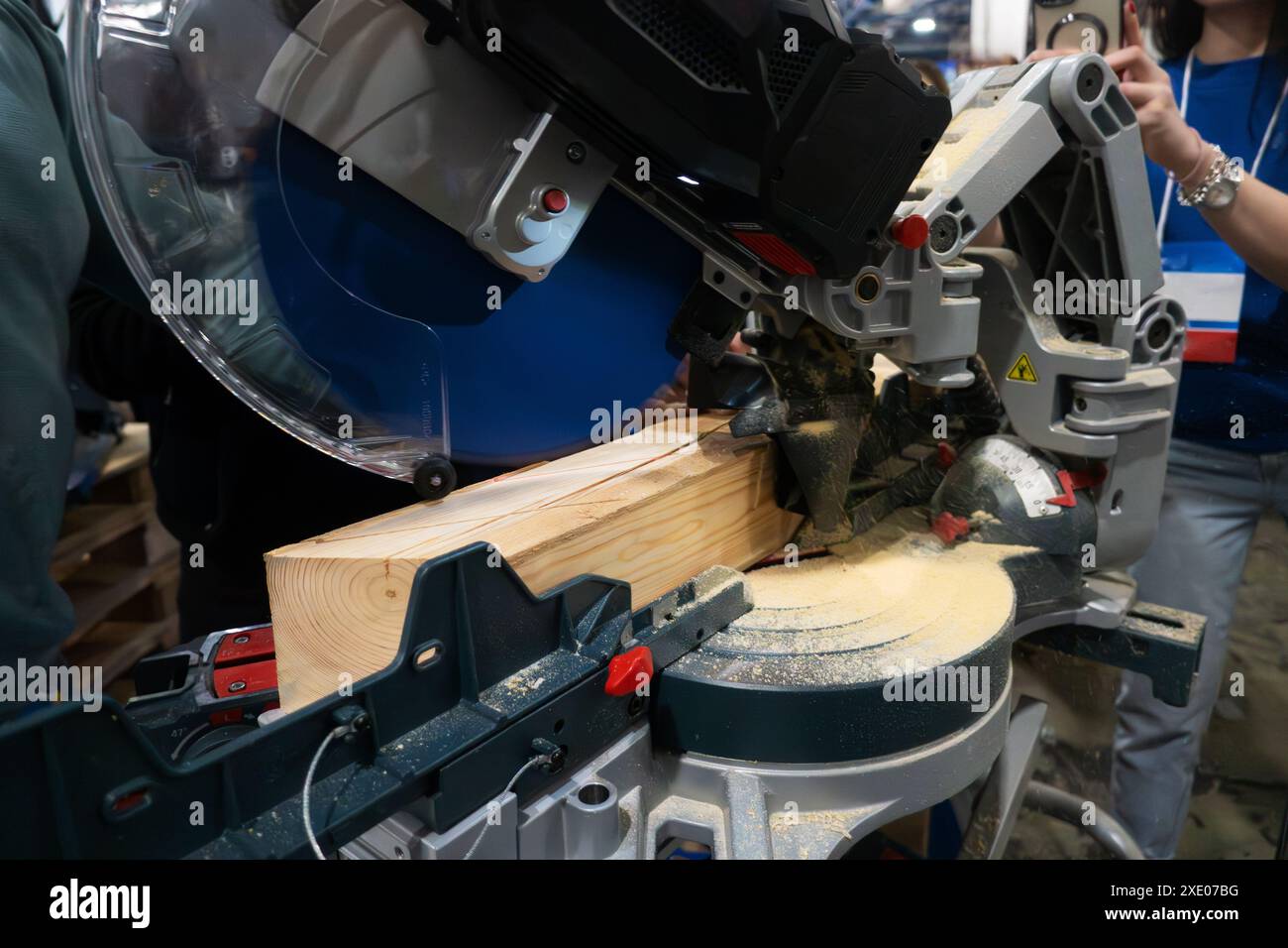 A worker cuts a wooden block using a circular saw Stock Photo