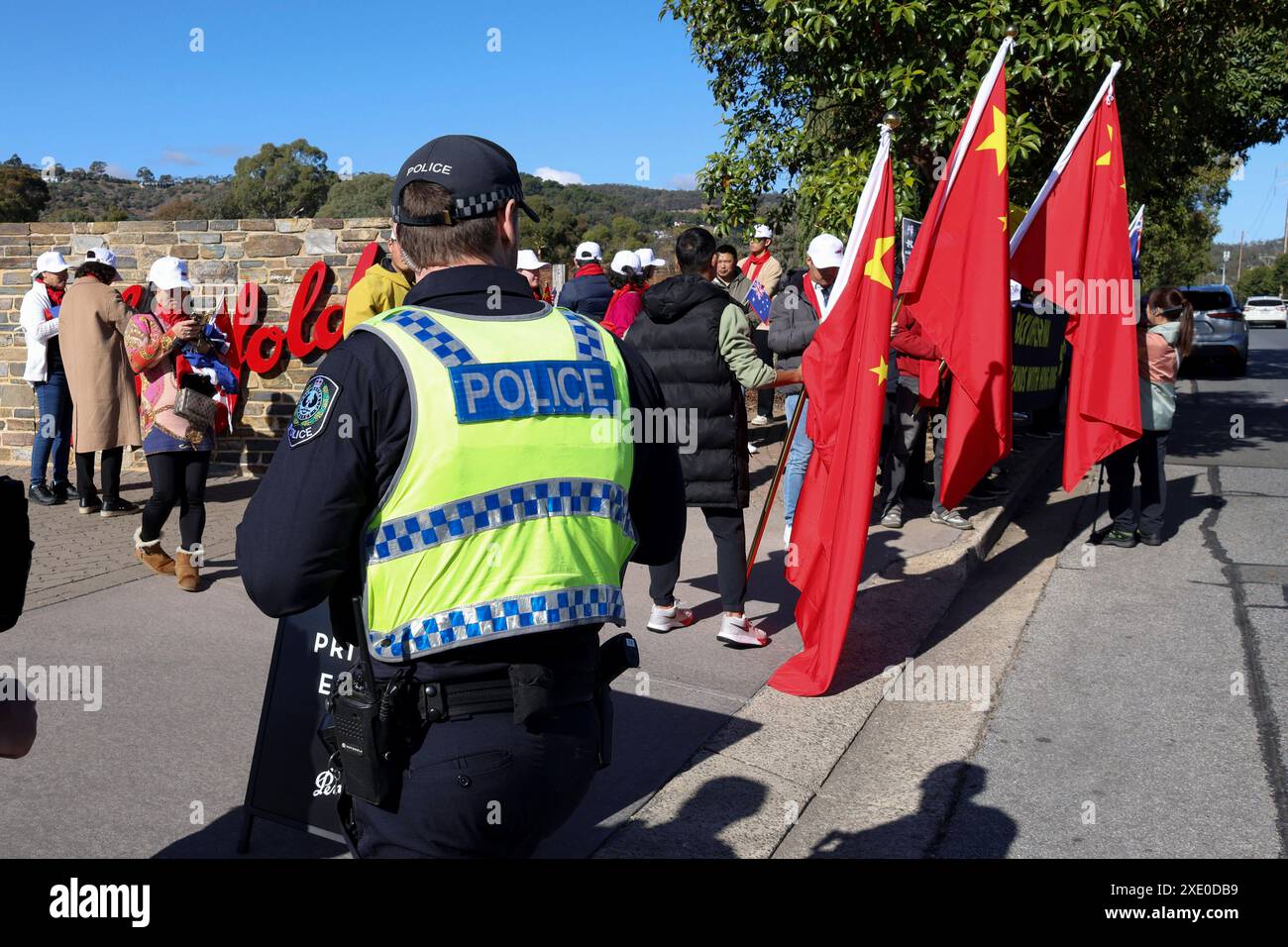 Police watch as Pro China and pro Hong Kong supporters wait outside a winery where Chinese Premier Li Qiang visited in Adelaide, Australia, Sunday, June 16, 2024. Li Qiang, who is second only to President Xi Jinping, is on a four-day visit to Australia. AAP Image/Pool, Kelly Barnes NO ARCHIVING ADELAIDE SA AUSTRALIA *** Police watch as Pro China and pro Hong Kong supporters wait outside a winery where Chinese Premier Li Qiang visited in Adelaide, Australia, Sunday, June 16, 2024 Li Qiang, who is second only to President Xi Jinping, is on a four day visit to Australia AAP Image Pool, Kelly Barn Stock Photo