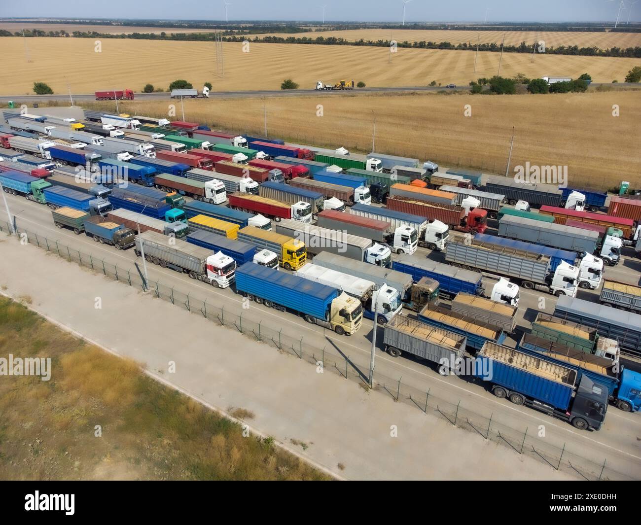 A long line of trucks in the port terminal. Trucks are waiting to unload grain. Stock Photo